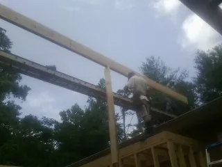 Carpenter setting a ridge beam over a new addition frame — Ice Dam Removal by Roofing Brothers in Richeyville