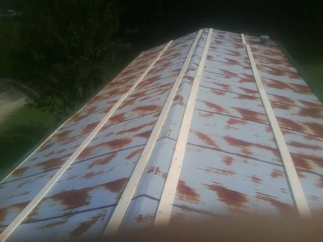 Rusted metal roof panels with new wood purlins before replacement — Storm Damage Roof Repair in Richeyville by Roofing Brothers