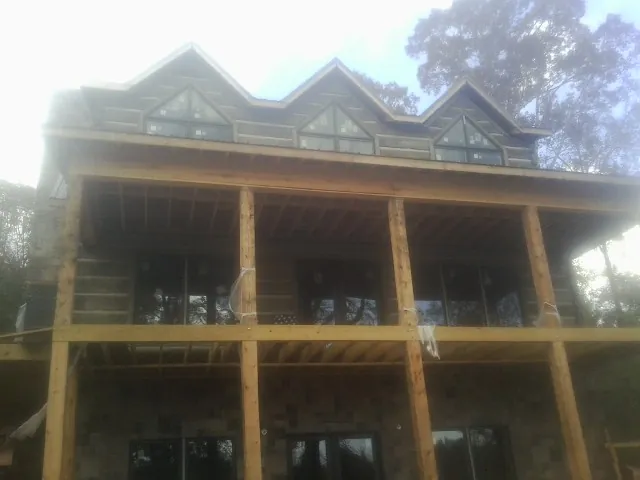 Dormers and porch framing on a large log home under construction — Roof Coating work by our crew in Richeyville